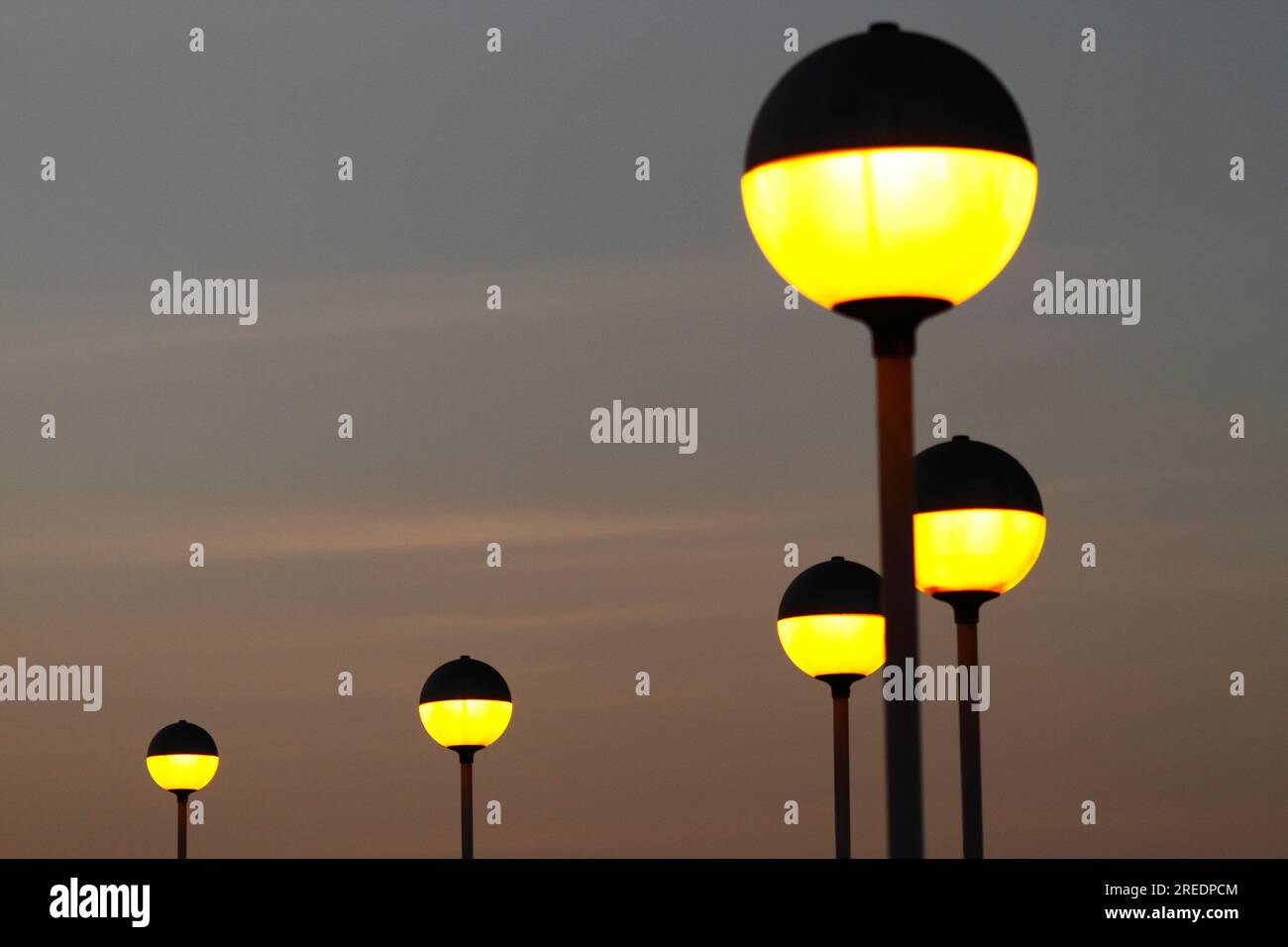 Spherical yellow street lamps on El Morro at sunset, Arica, Chile Stock Photo