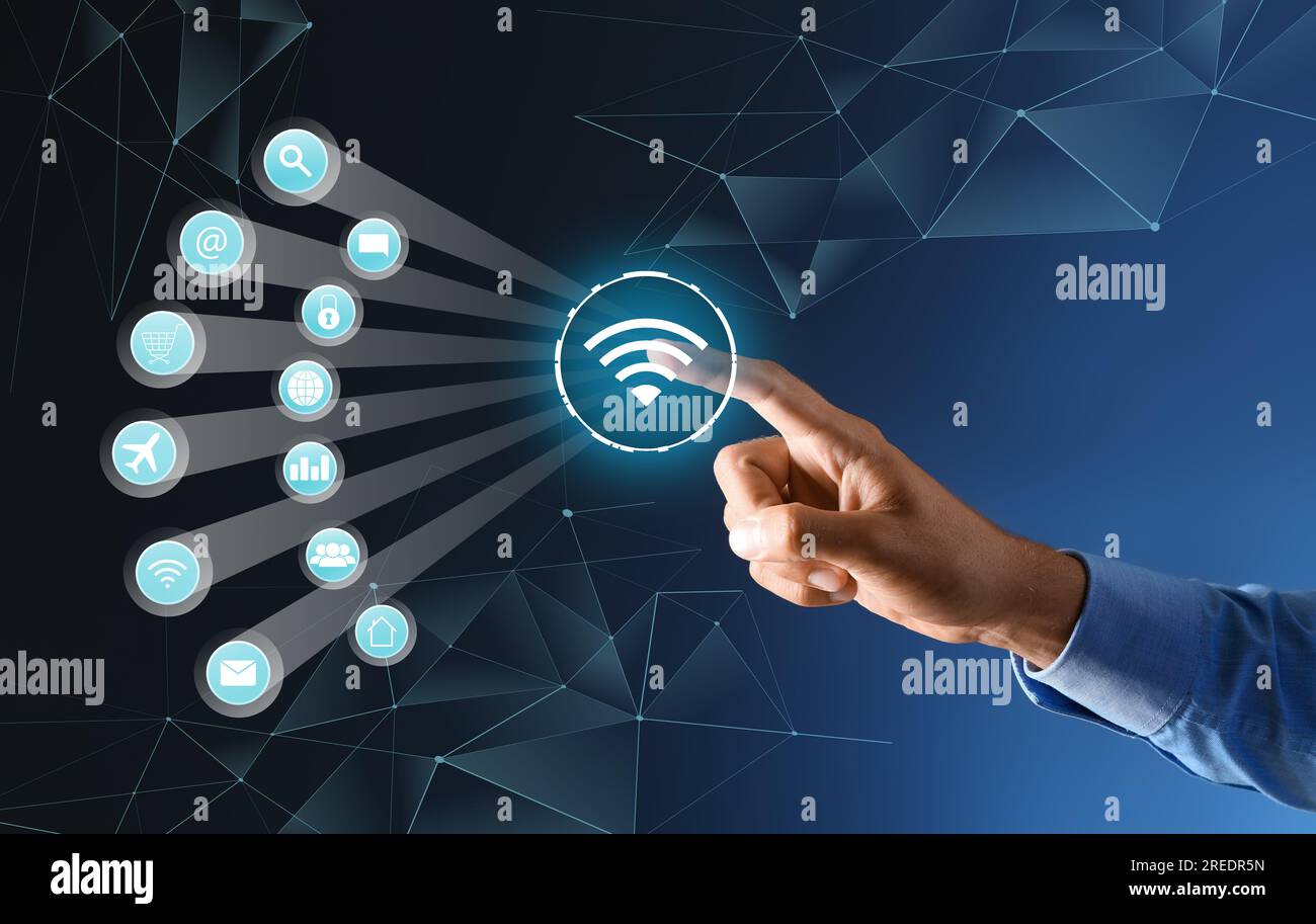 Businessman using virtual screen with digital wifi icon on dark blue background Stock Photo