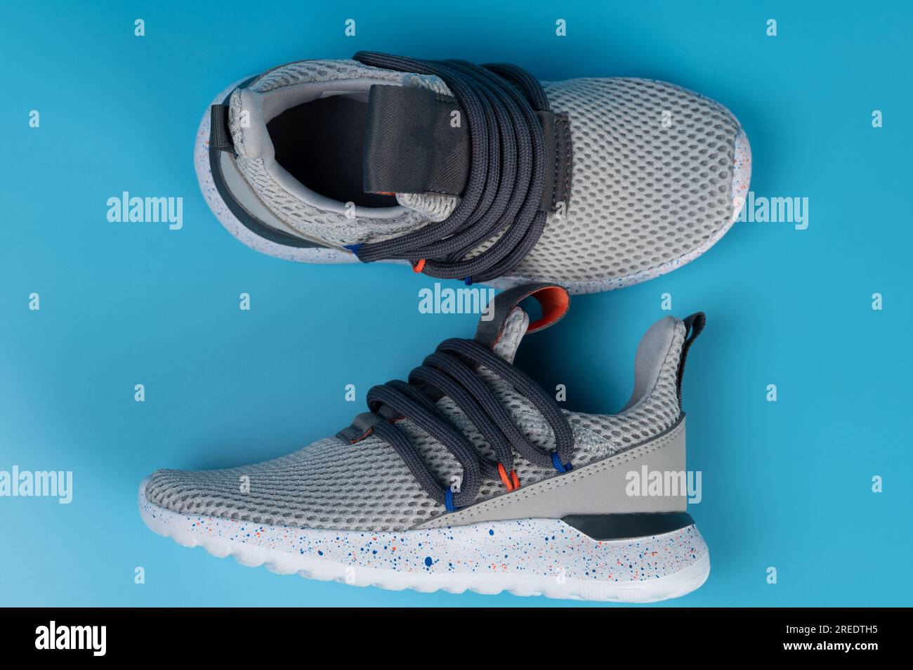 Modern gray running pair shoes above top view isolated on blue studio background Stock Photo