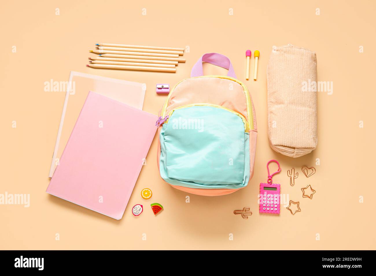 Stylish school backpack with different stationery on orange background Stock Photo