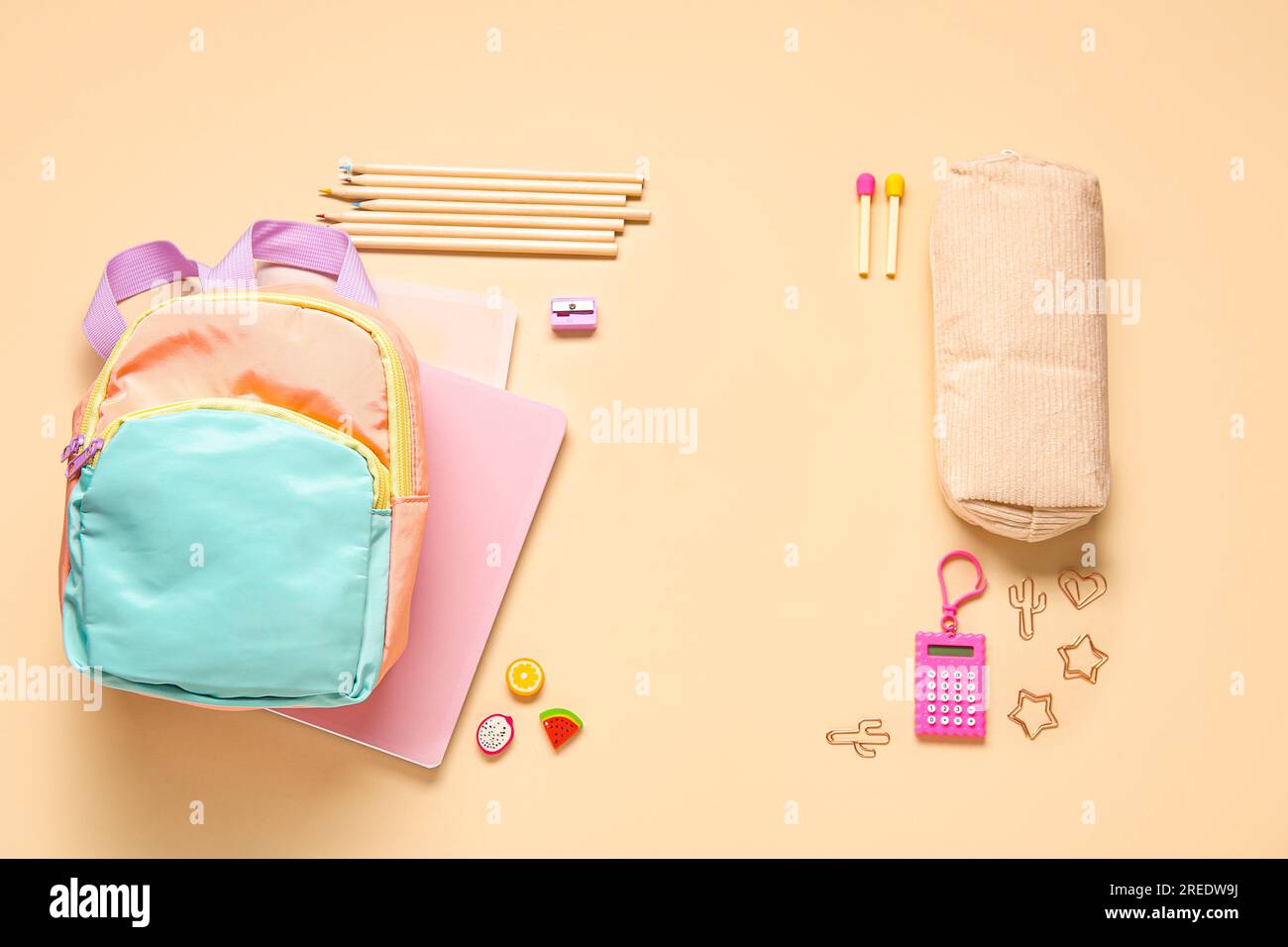 Stylish school backpack with different stationery on orange background Stock Photo