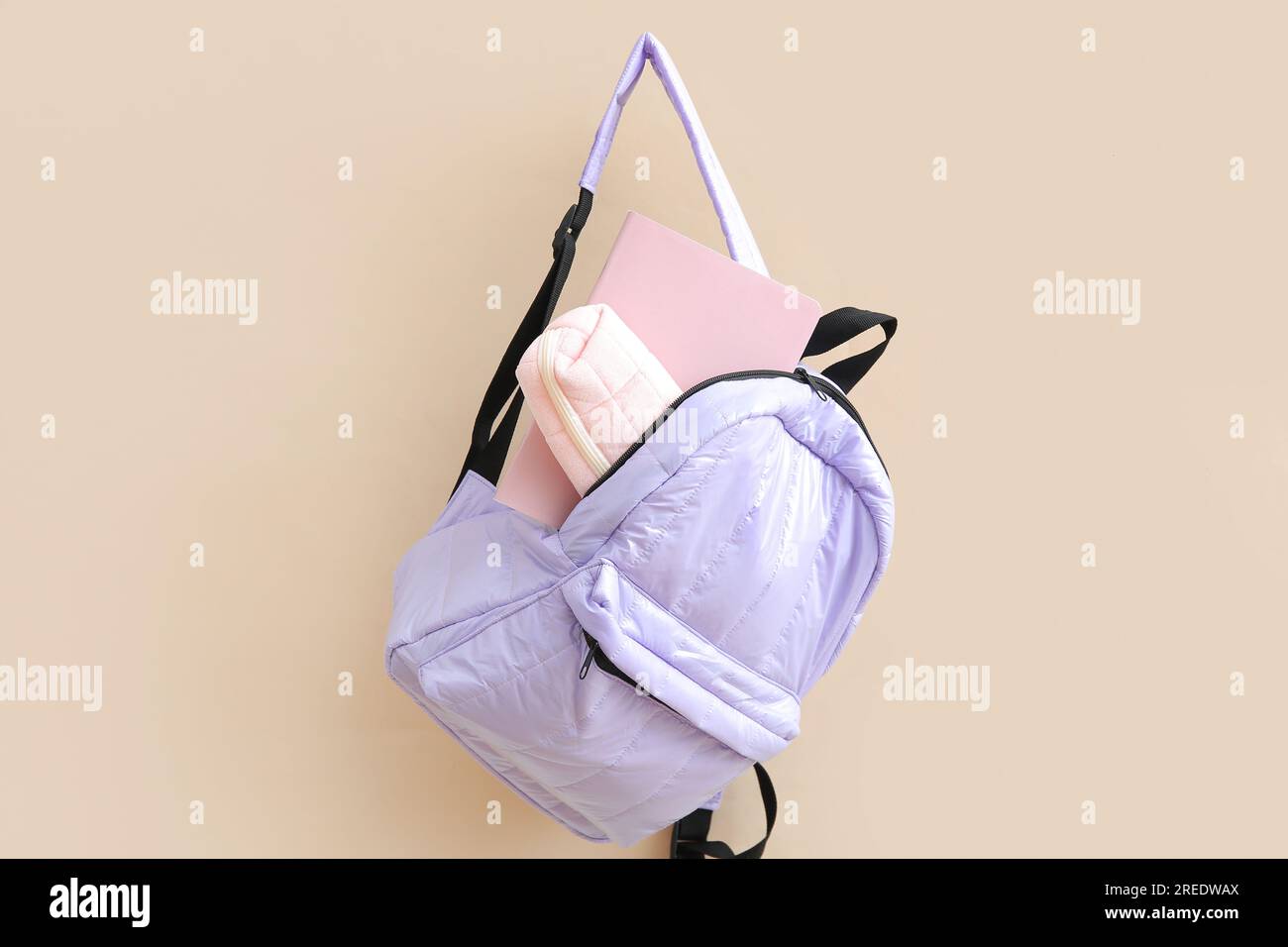 Lilac school backpack with stationery on beige background Stock Photo