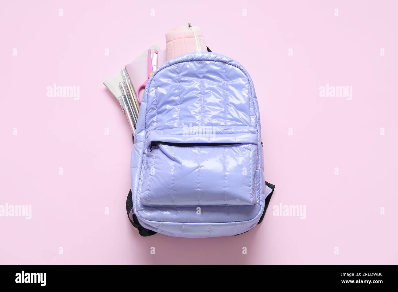 Lilac school backpack with stationery on pink background Stock Photo
