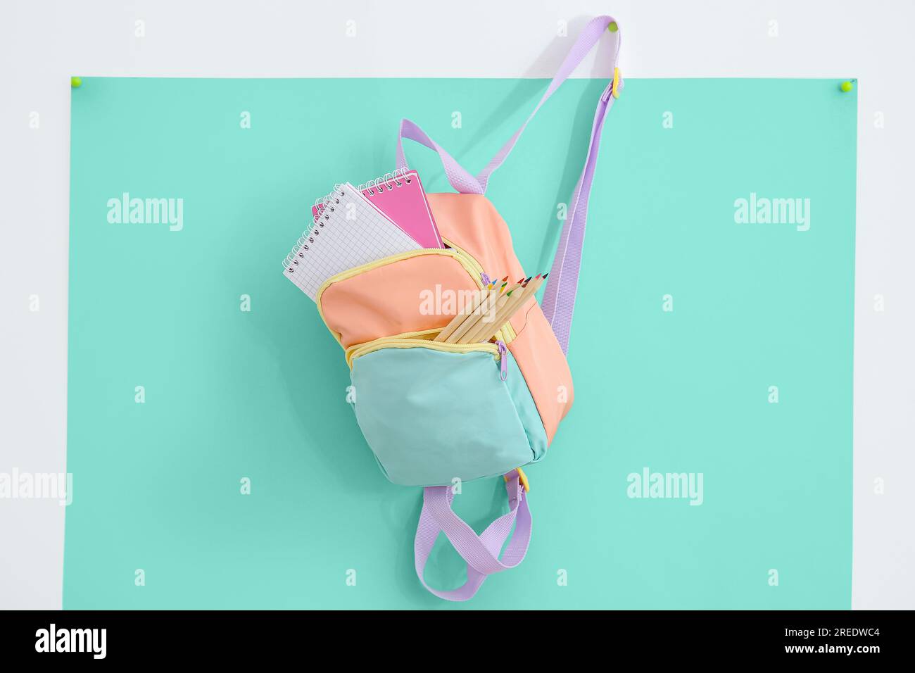 Color school backpack with stationery on turquoise background Stock Photo