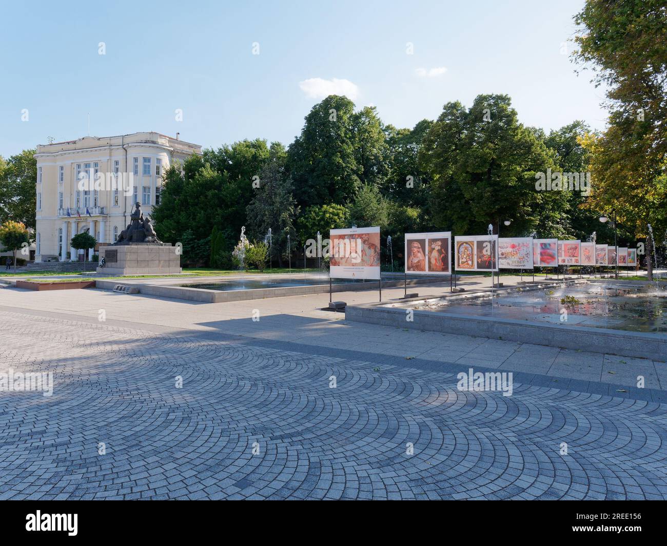 Yellow mansion style building beside a park and water feature  in the centre of Plovdiv, Bulgaria Stock Photo