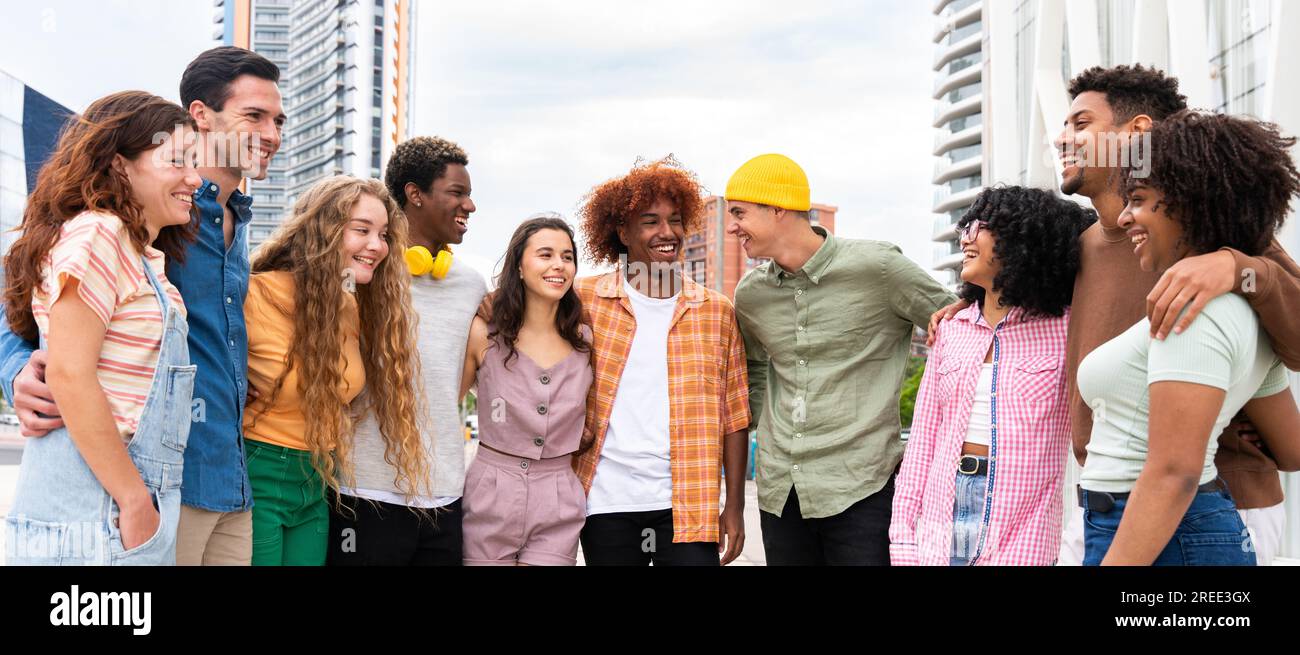 Happy playful multiethnic group of young friends bonding outdoors - Multiracial millennials students meeting in the city, concepts of youth, people li Stock Photo