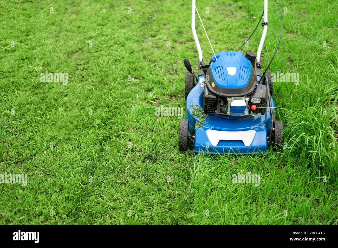Lawn mower cutting grass. Small grass cuttings fly out of