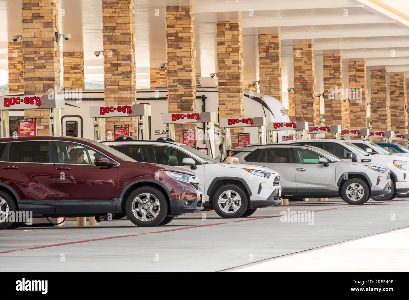 Sevierville, Tennessee, United States – July 24, 2023: Horizontal shot of a row of suvs buying gasoline at Tennessee Buc-ee’s facility. Stock Photo