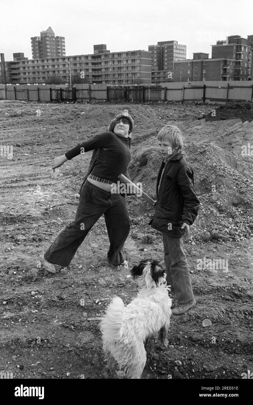 Kids playing play fighting, outdoors on waste ground throwing stones