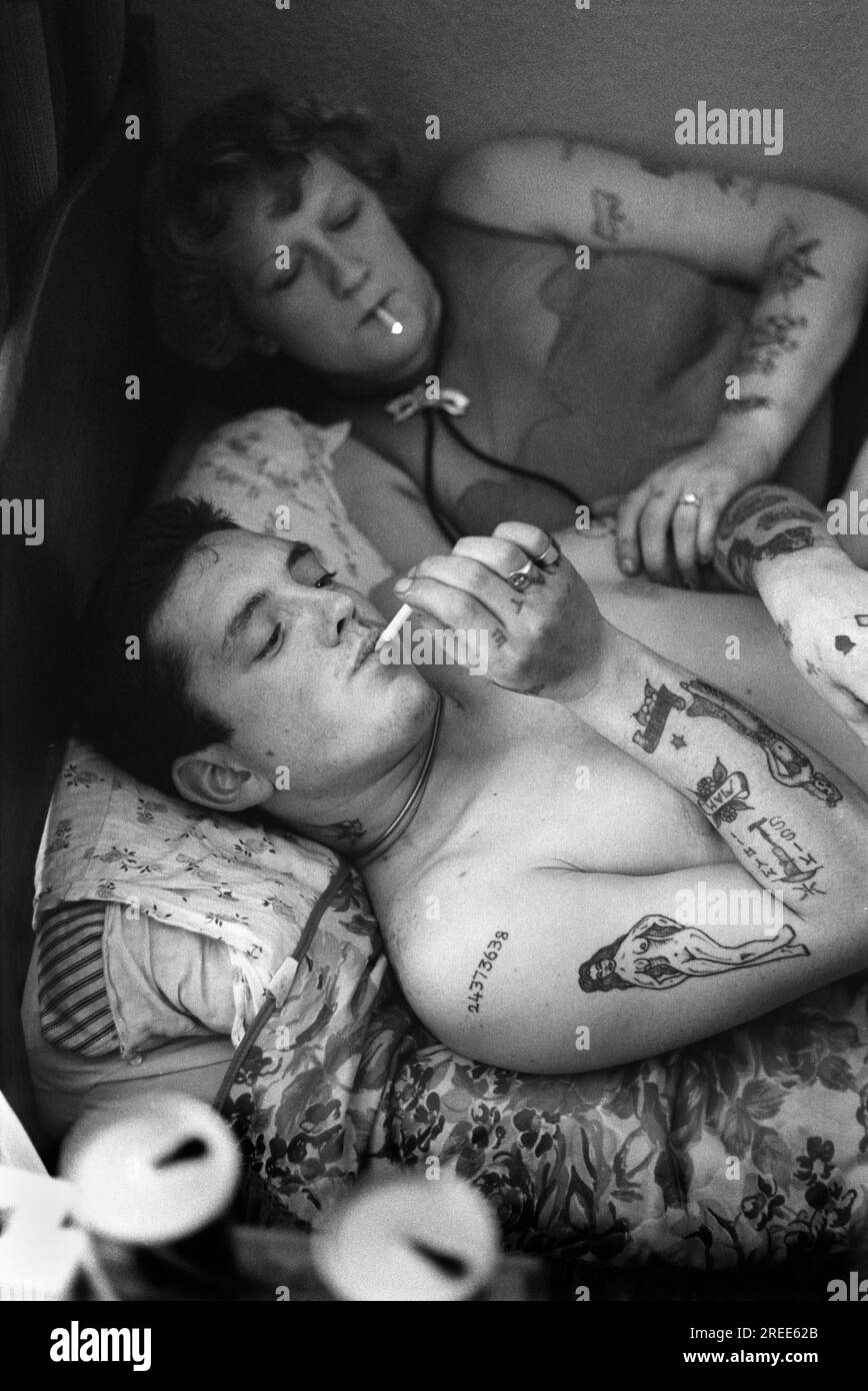 Earls Court bedsit young couple lying on a single bed. and having a smoke. London 1977 1970s UK HOMER SYKES Stock Photo