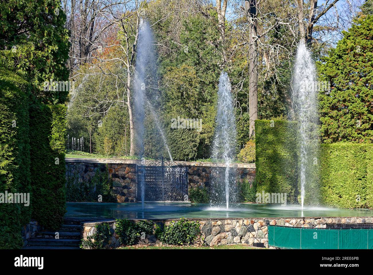 fountains spouting columns, water, trees, stone walls, wrought iron