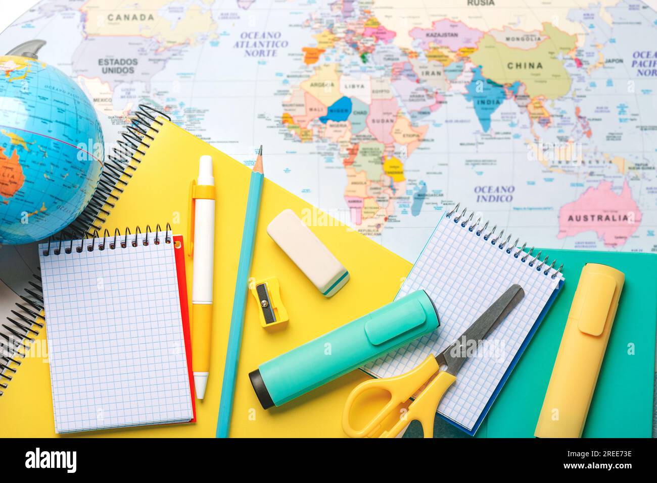 Top view of notebooks,school supplies and earth globe on a world map. Back to school concept Stock Photo