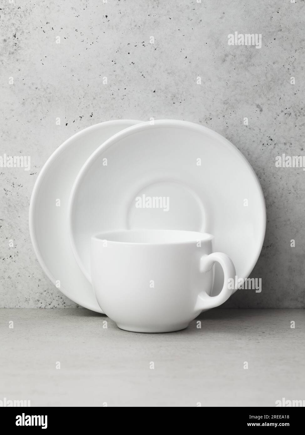 Two white ceramic saucers and one cup on the table Stock Photo