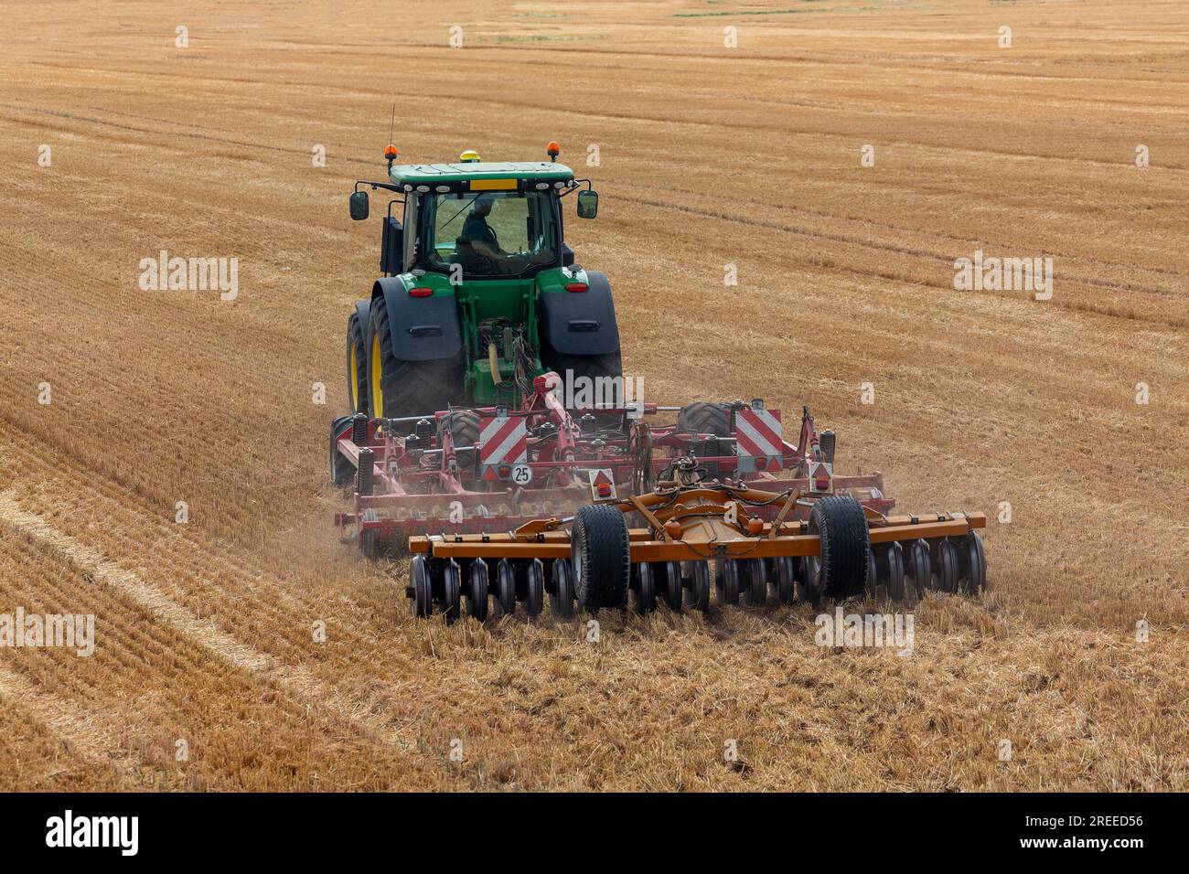 Summer farming in the South of England. Rear view of tractor and plough as it moves away. Stock Photo