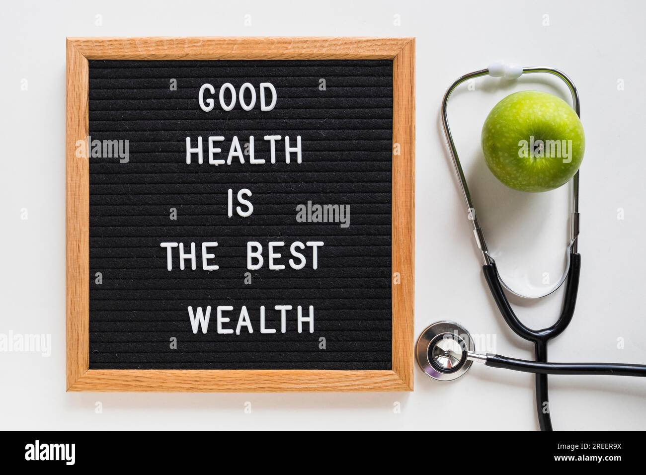 Good health message board with green apple stethoscope white background