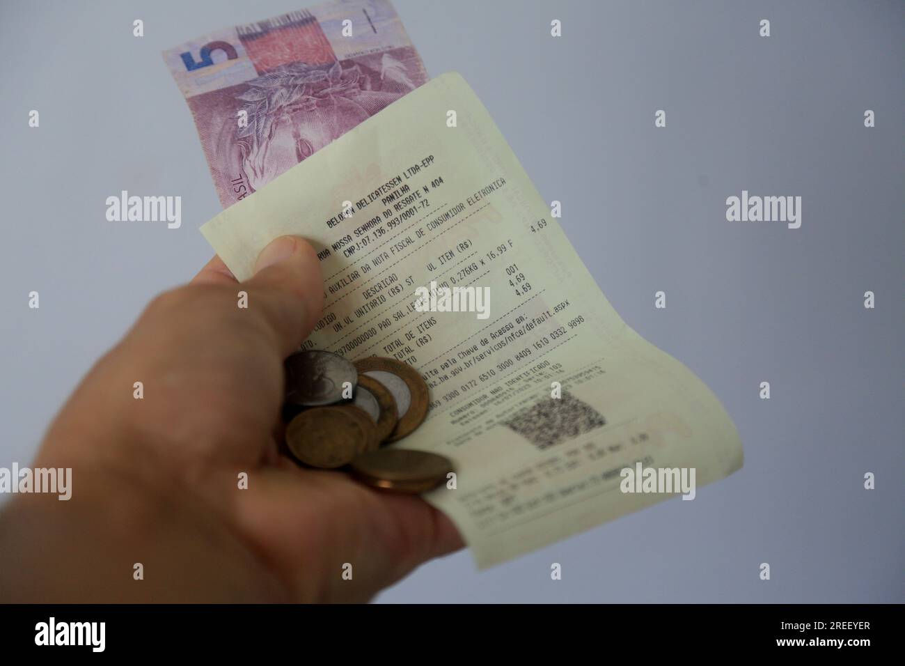 salvador, bahia, brazil - july 15, 2023: hand holds invoice with QR ...