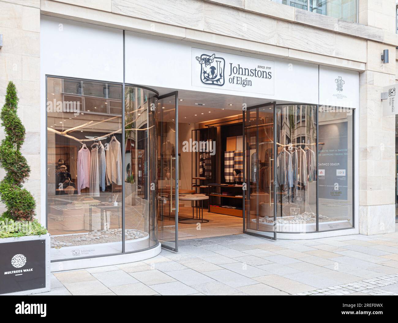 Front of and open entrance to the Johnstons of Elgin luxury wool and cashmere clothes shop in Multrees Walk in central Edinburgh. Stock Photo