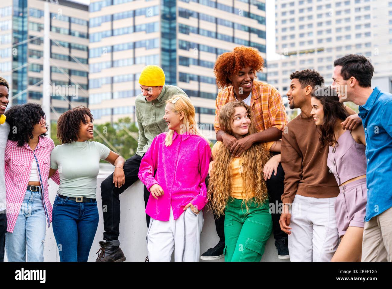 Happy playful multiethnic group of young friends bonding outdoors - Multiracial millennials students meeting in the city, concepts of youth, people li Stock Photo