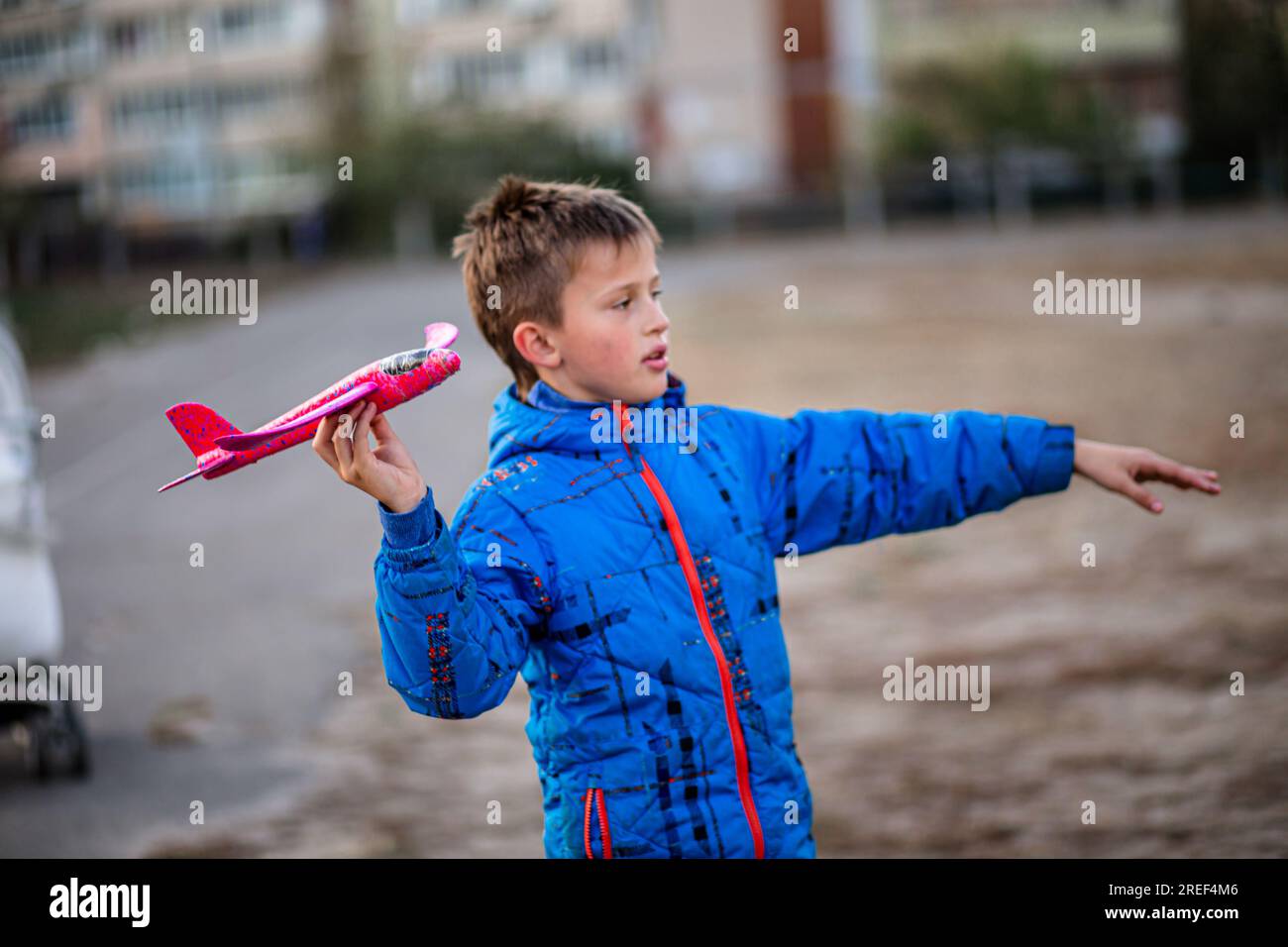 boy delights in launching his toy plane. travel and exploration. Children's development through outdoor games. Stock Photo