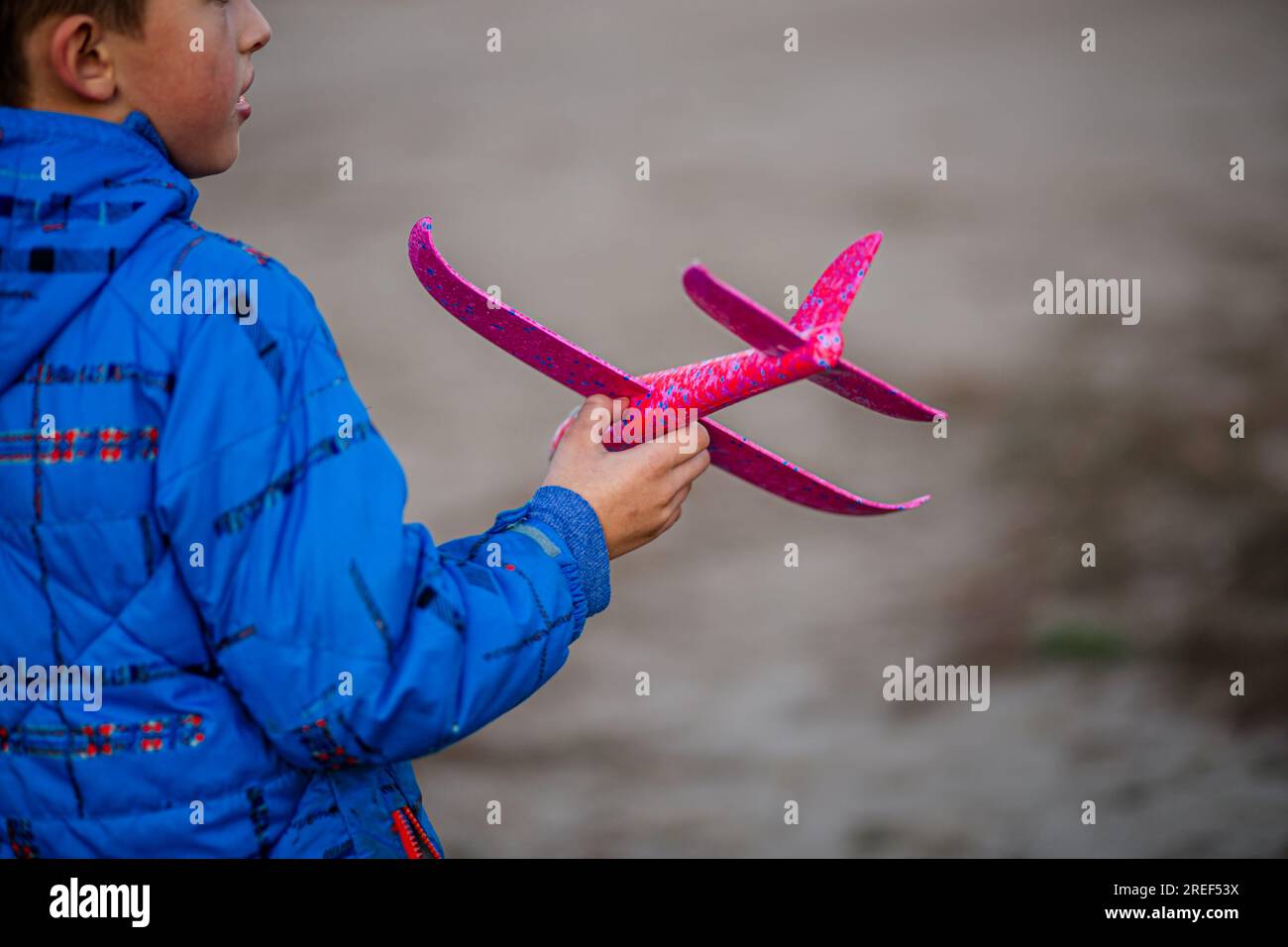 boy's sends his toy plane soaring. the world of airplanes and piloting in the autumn camp. Stock Photo