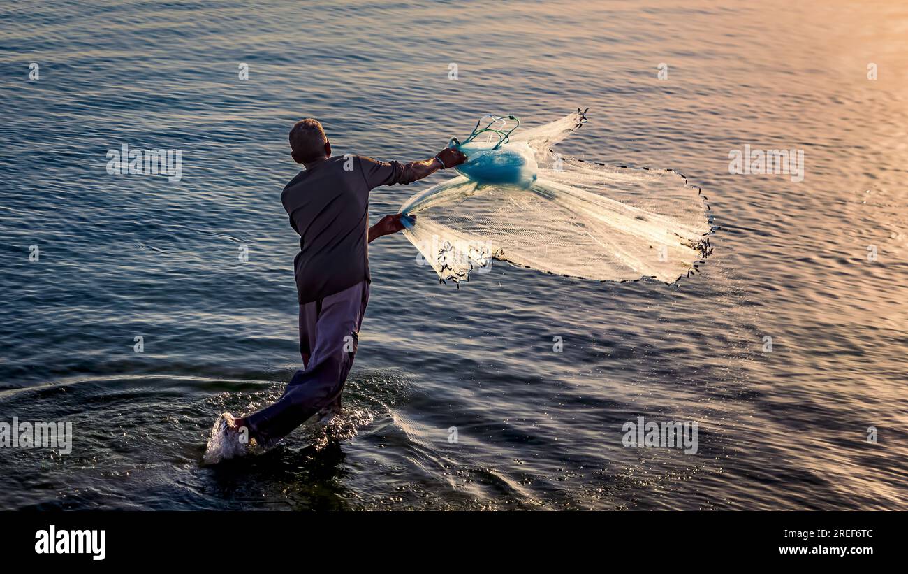 A fishermen throwing fishing net during sunrise in Al Khobar seaside