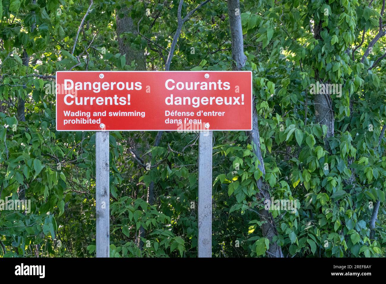 Sign posted at Point Pelee National Park warning visitors that the shore of Lake Erie has dangerous currents and waves and that swimming and wading is Stock Photo
