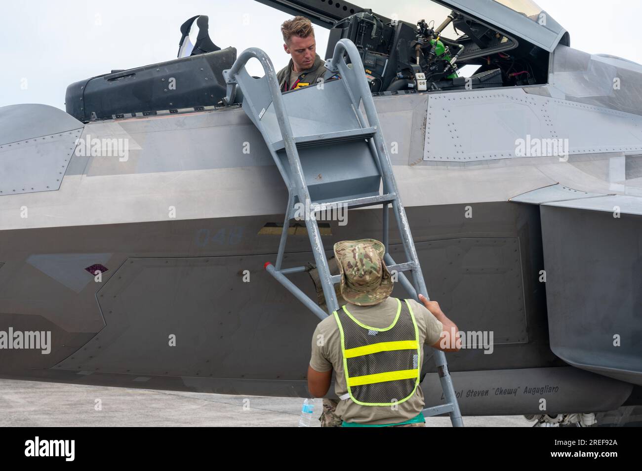 A U.S. Air Force Airman assists the pilot of an F-22 Raptor in deplaning during Cope Thunder 23-2 at Clark Air Base, Philippines, July 7, 2023. Bilateral training exercises like Cope Thunder 23-2 helped to reinforce the U.S.’ commitment to peace and prosperity in the region. (U.S. Air Force photo by Senior Airman Vaughn Weber) Stock Photo