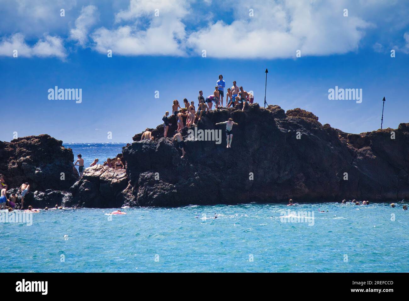 Unrecognizable dstant cliff divers at Black Rock on Maui Stock Photo