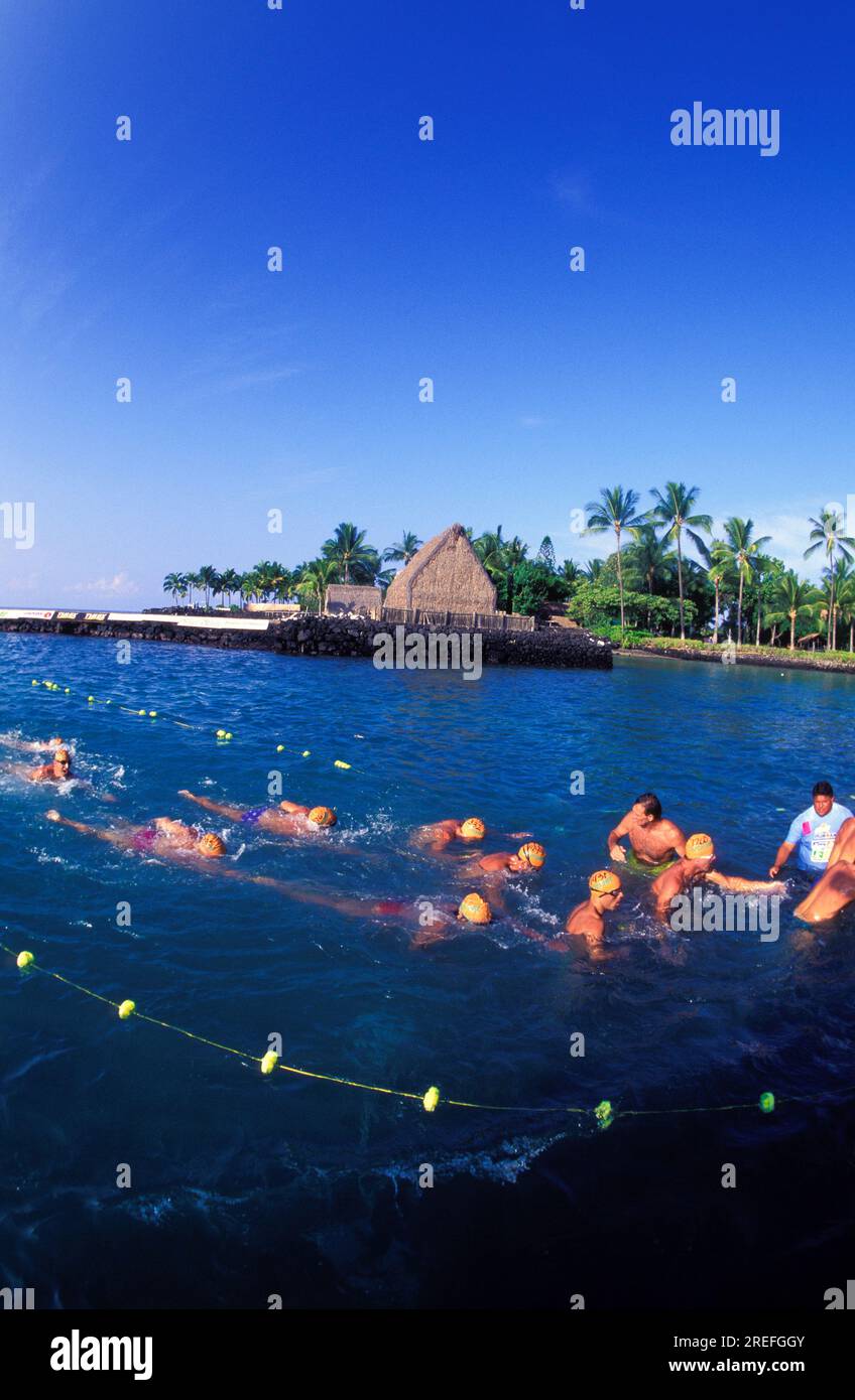Swimmers at the finish line at the annual Ironman Triatholon in Kailua-Kona with ahuena heiau in background. Stock Photo