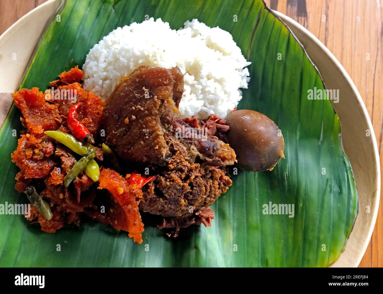 Nasi Gudeg. Traditional Java Javanese Yogyakarta meal of rice, young jack fruit stew with egg, spicy cattle skin cracker stew and white chicken curry Stock Photo