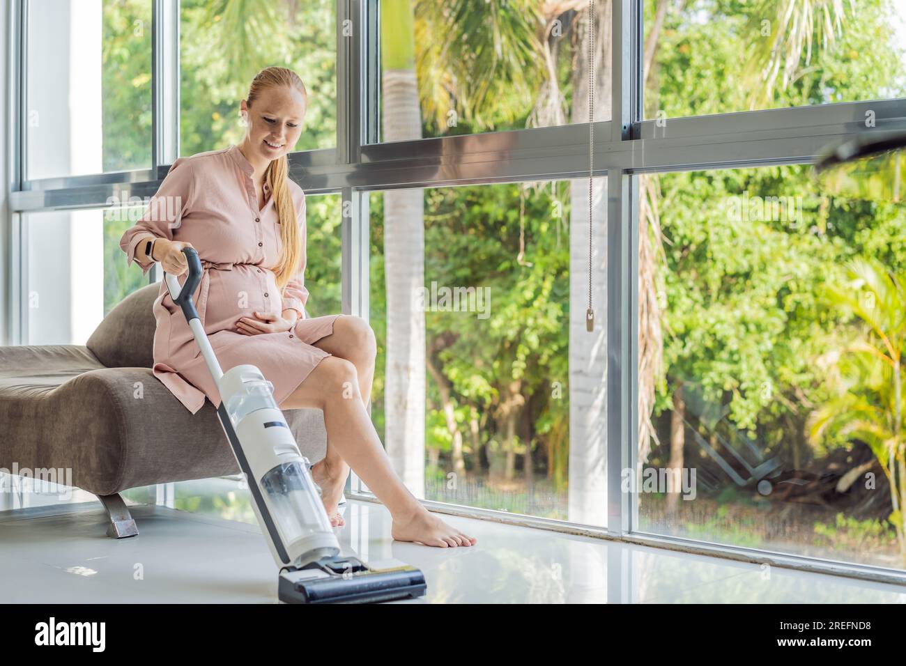 Young pregnant woman enjoys cleaning her house. Easy cleaning with a