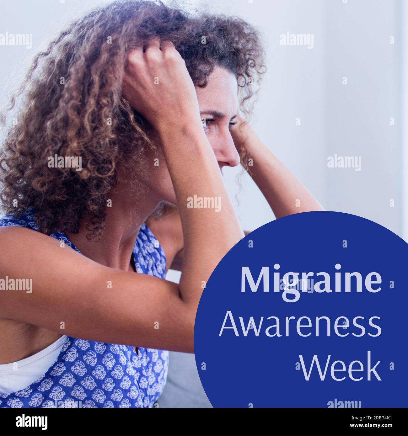 Migraine awareness week text in white on blue with caucasian woman clutching hair in pain Stock Photo