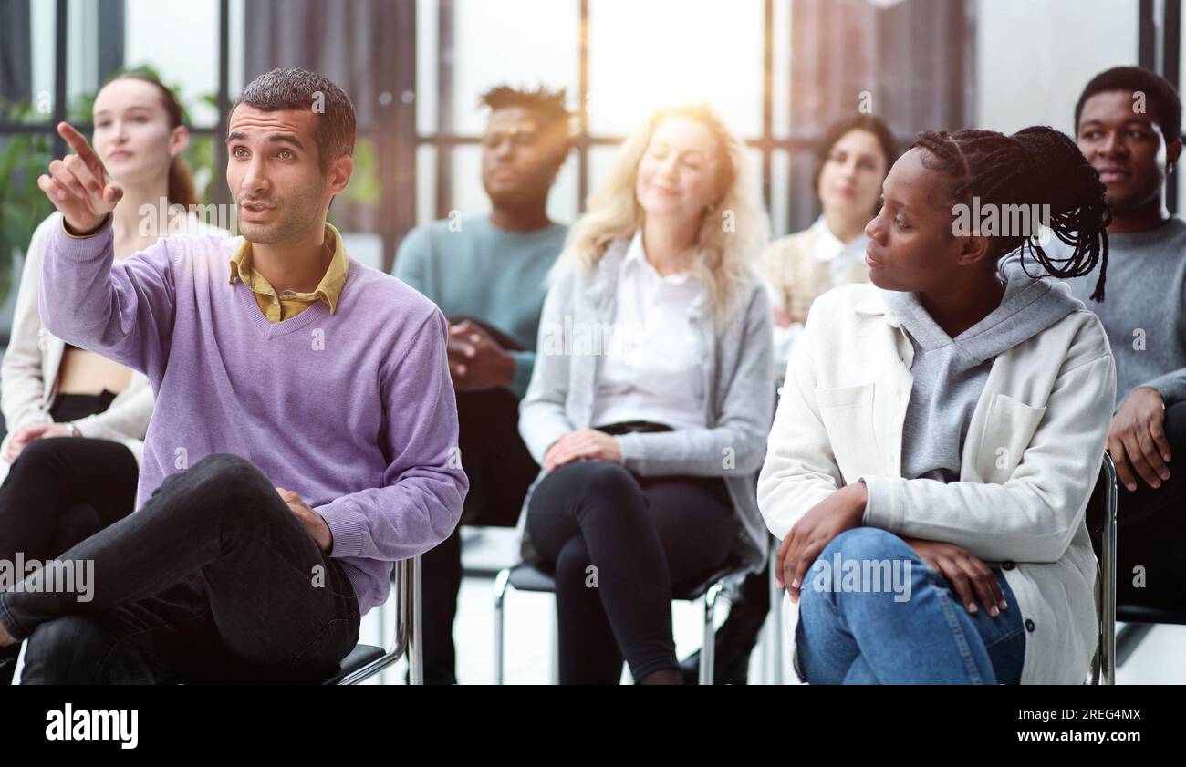 Close-up of people chatting, sitting in a circle and gesturing Stock Photo