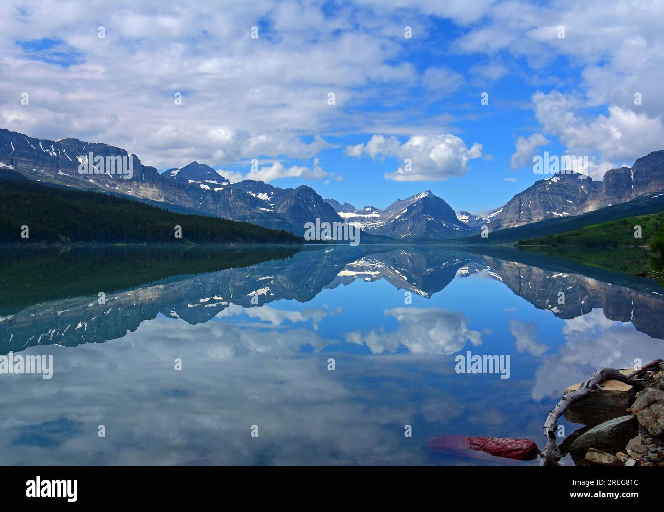 cloud reflection and peaks of glacier national park in mirrorlike surface of lake sherburne in many glacier valley, on way to  many glacier, montana Stock Photo