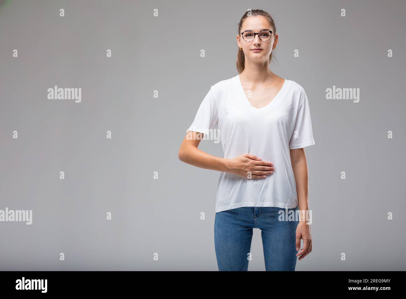 Hand on stomach, a woman indicates problems with digestion or female