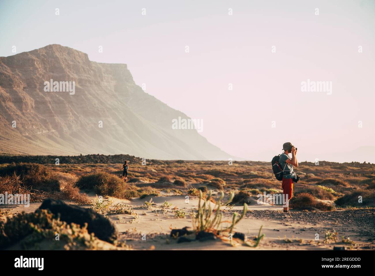 A young boy takes pictures of the sunset in a beautiful desert in lanz Stock Photo