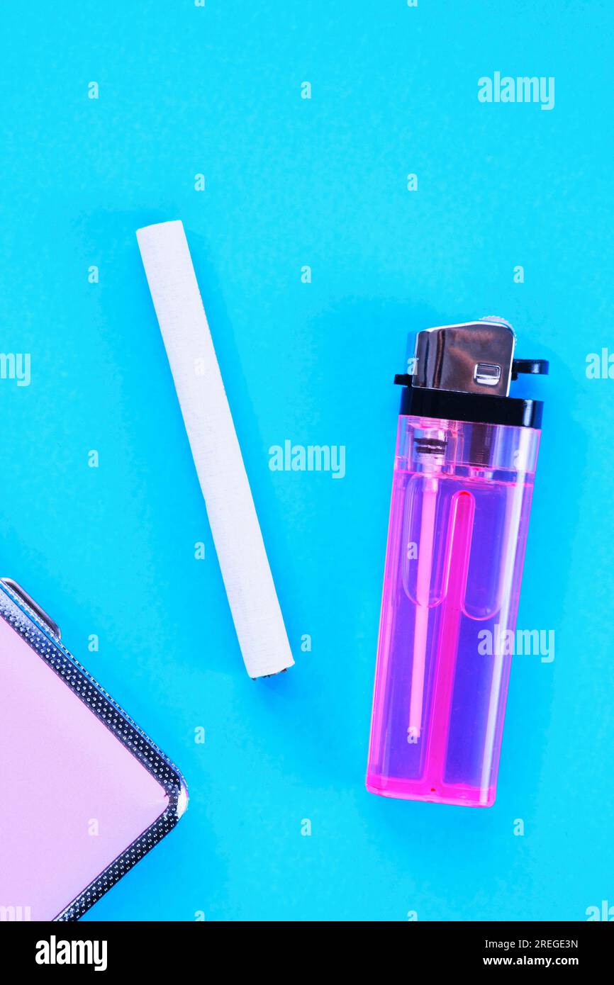 Cigarette, case and lighter against pale blue Stock Photo