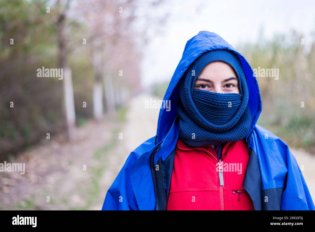 Front view of a woman wearing a ski mask while standing outdoors and looking camera Stock Photo