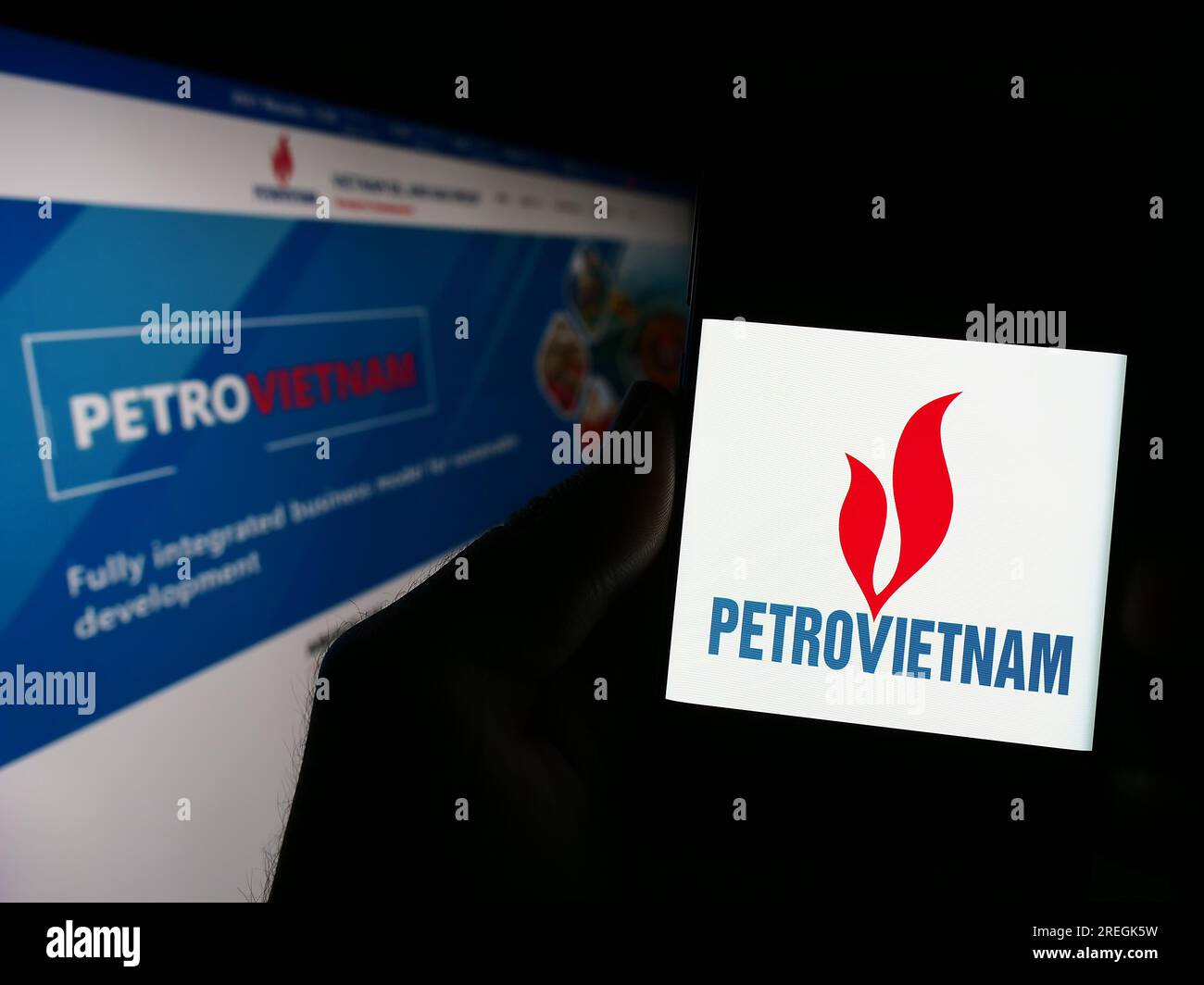 Person holding smartphone with logo of oil and gas company PetroVietnam