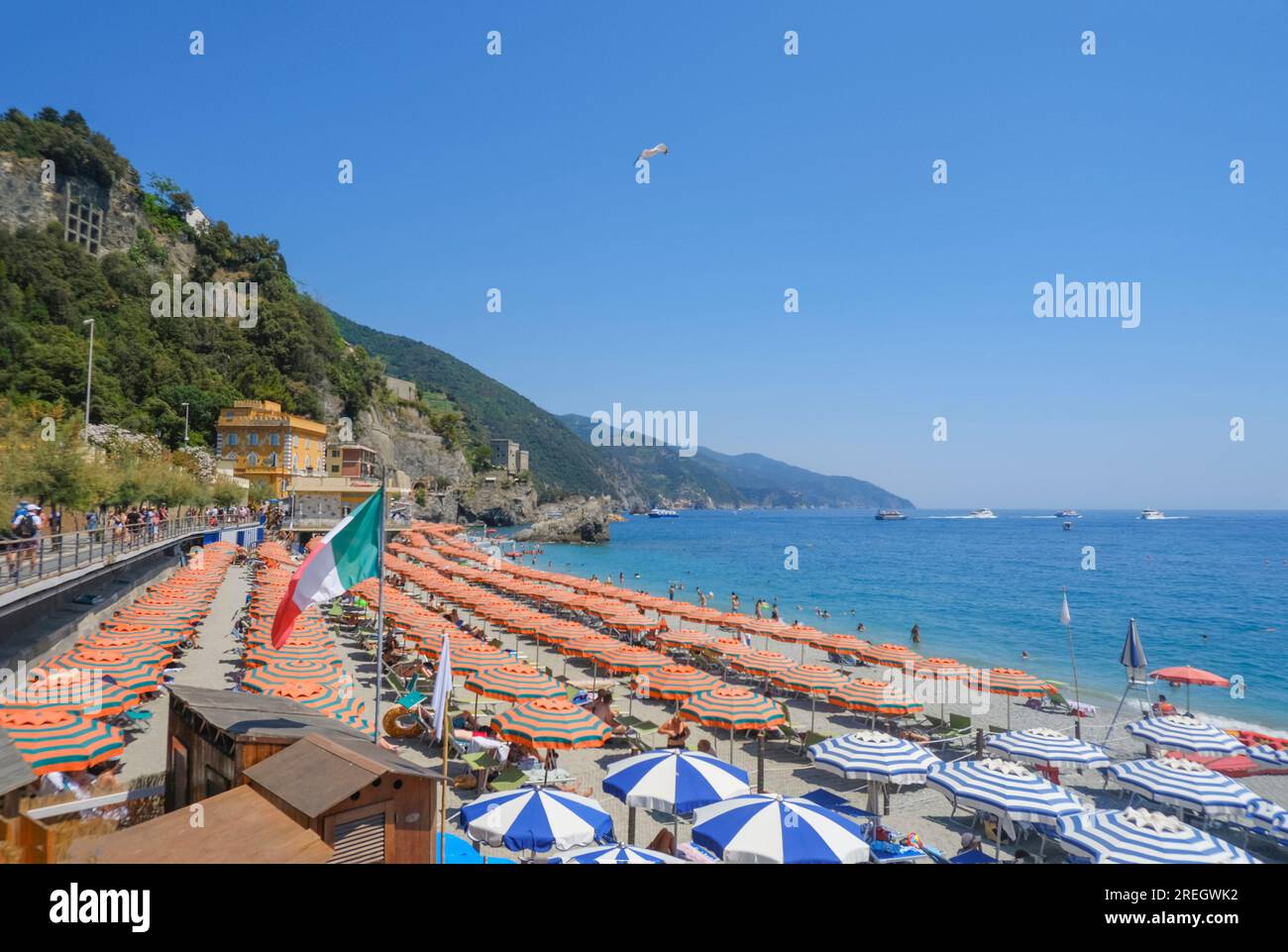 orange beach umbrellas on the beach of Monterosso, Cinque Terre, The Ligurian Sea, Liguria, Italy, Italian Riviera Stock Photo
