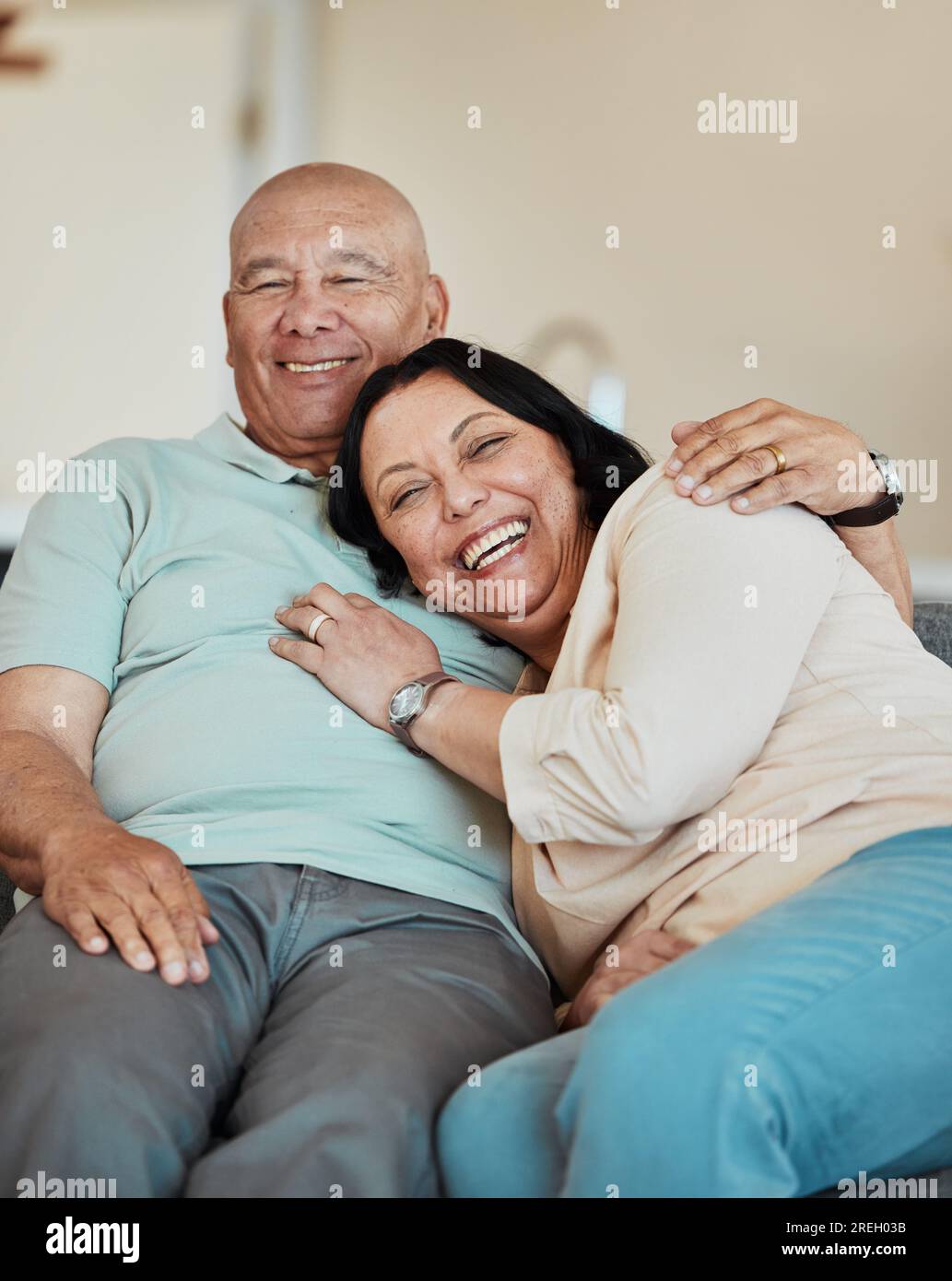 Funny, portrait and senior couple in home living room, bonding and relax together for retirement. Face, laughing and elderly man and woman hug on sofa Stock Photo