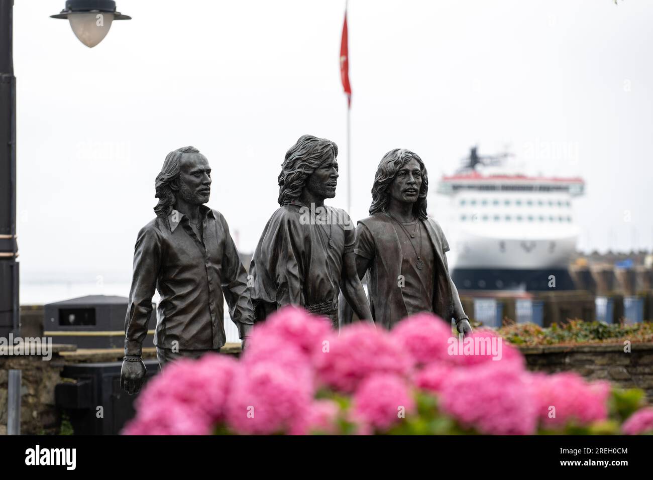 Bronze statue on Douglas promenade erected to celebrate the Bee Gees born on the Isle of Man. Steam Packet Company flagship, Manxman in the background Stock Photo