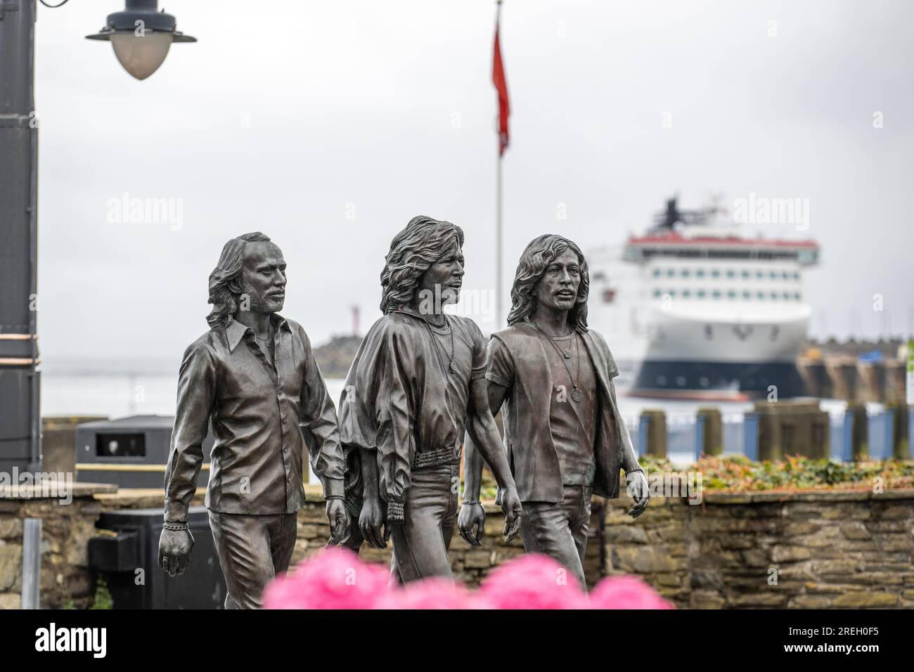 Bronze statue on Douglas promenade erected to celebrate the Bee Gees born on the Isle of Man. Steam Packet Company flagship, Manxman in the background Stock Photo