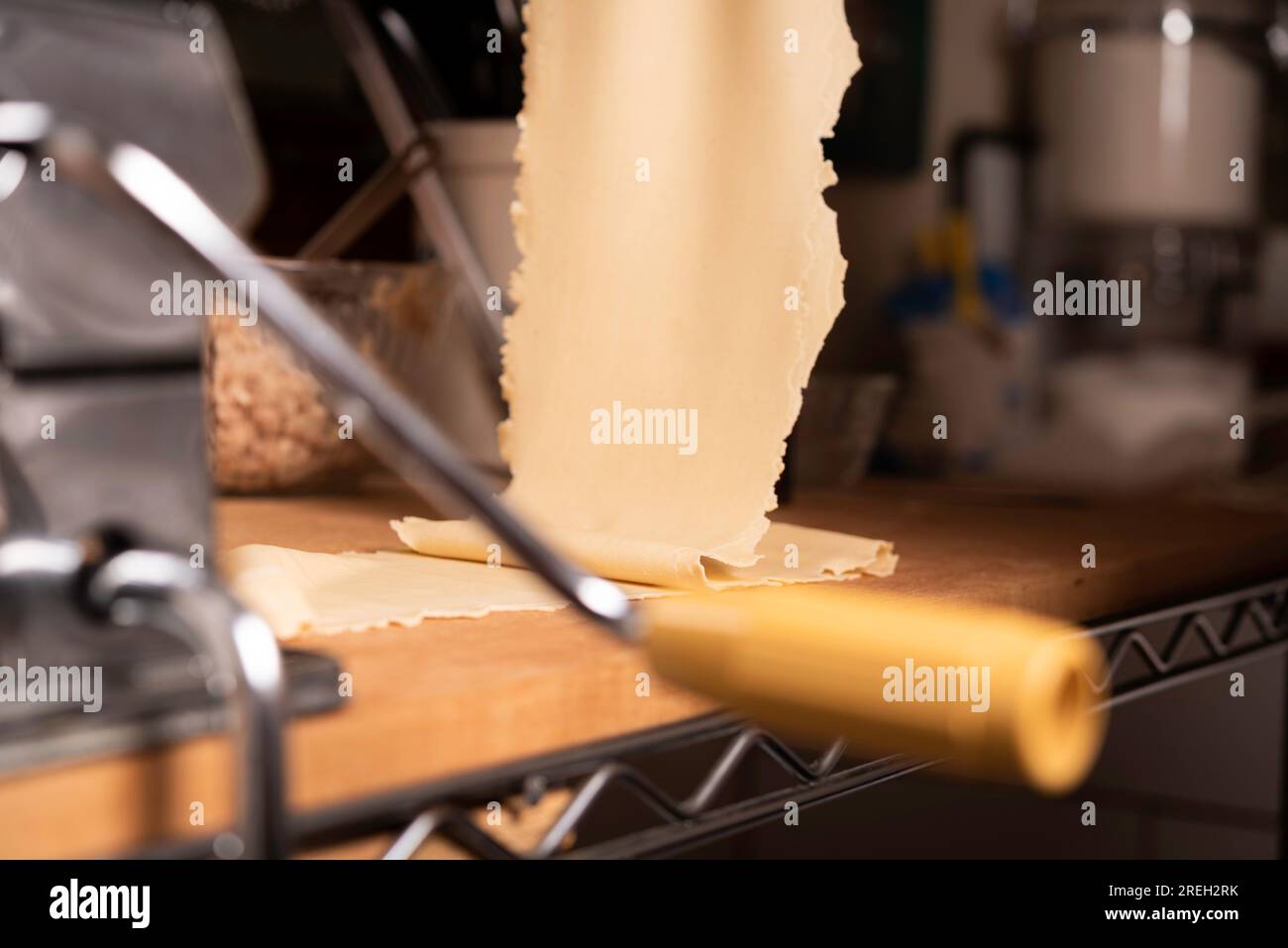 https://c8.alamy.com/comp/2REH2RK/making-pasta-and-tortellini-at-home-on-wooden-rack-and-chrome-pasta-maker-2REH2RK.jpg