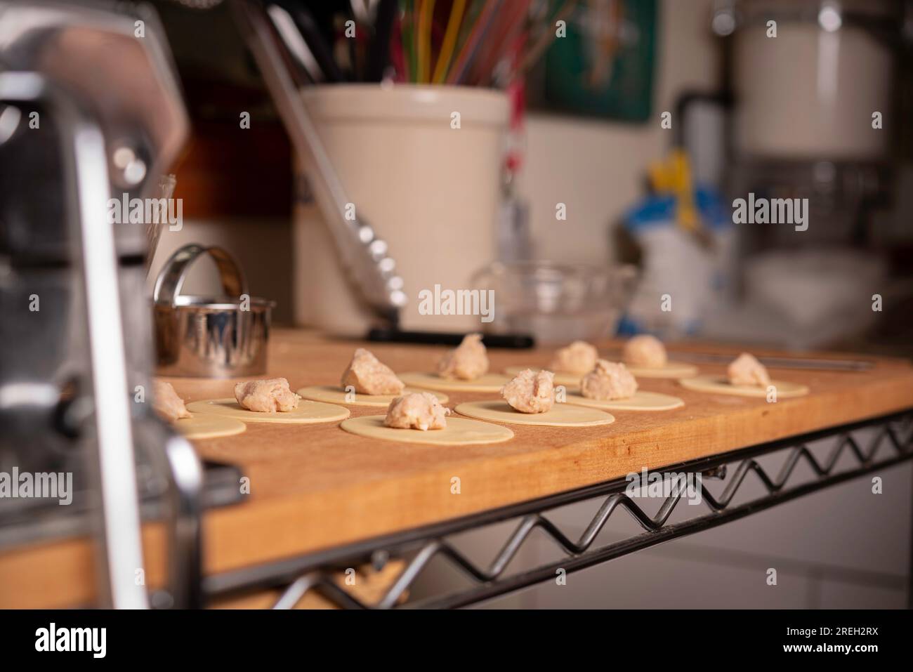 https://c8.alamy.com/comp/2REH2RX/making-pasta-and-tortellini-at-home-on-wooden-rack-and-chrome-pasta-maker-2REH2RX.jpg