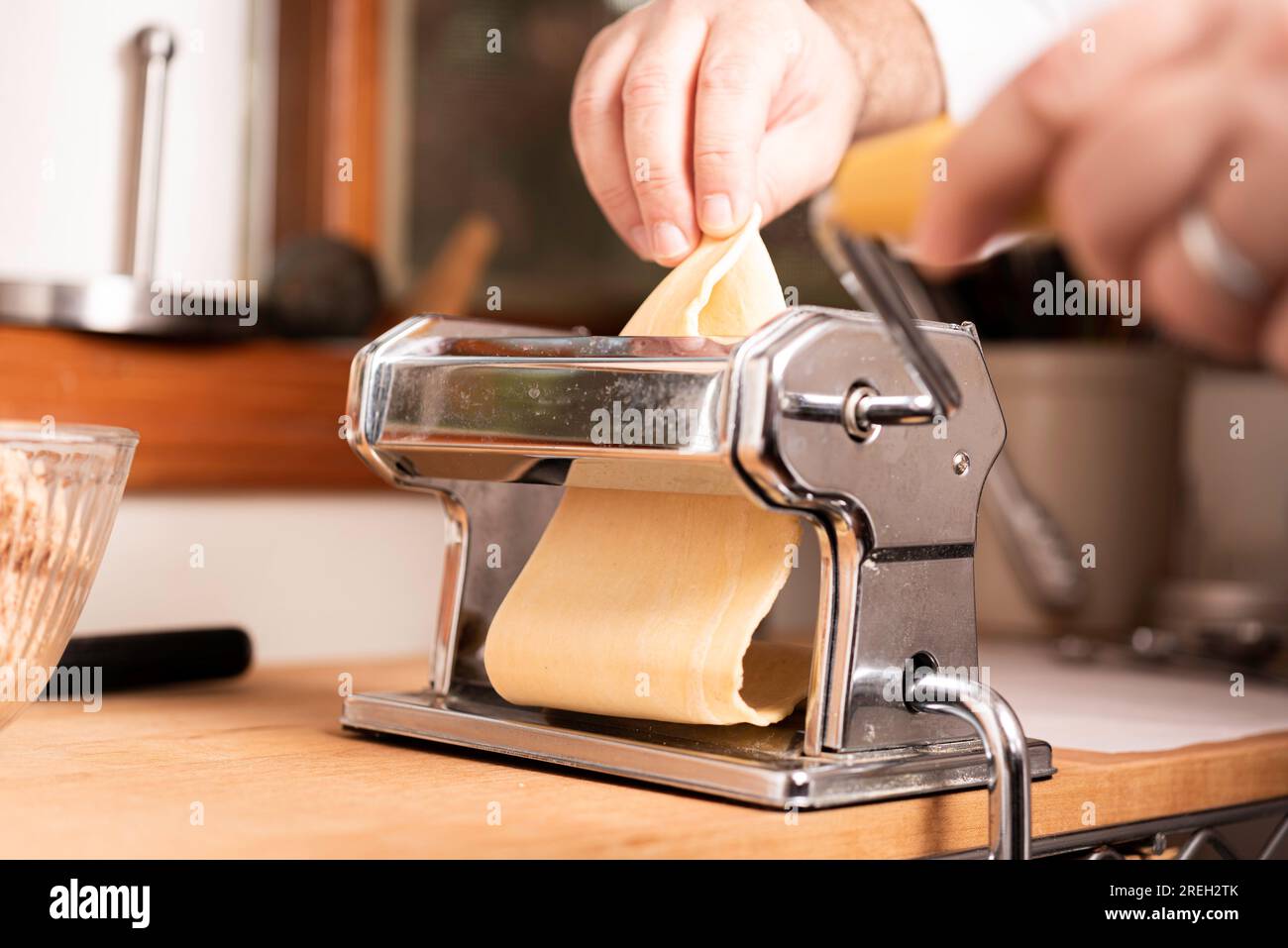 https://c8.alamy.com/comp/2REH2TK/making-pasta-and-tortellini-at-home-on-wooden-rack-and-chrome-pasta-maker-2REH2TK.jpg