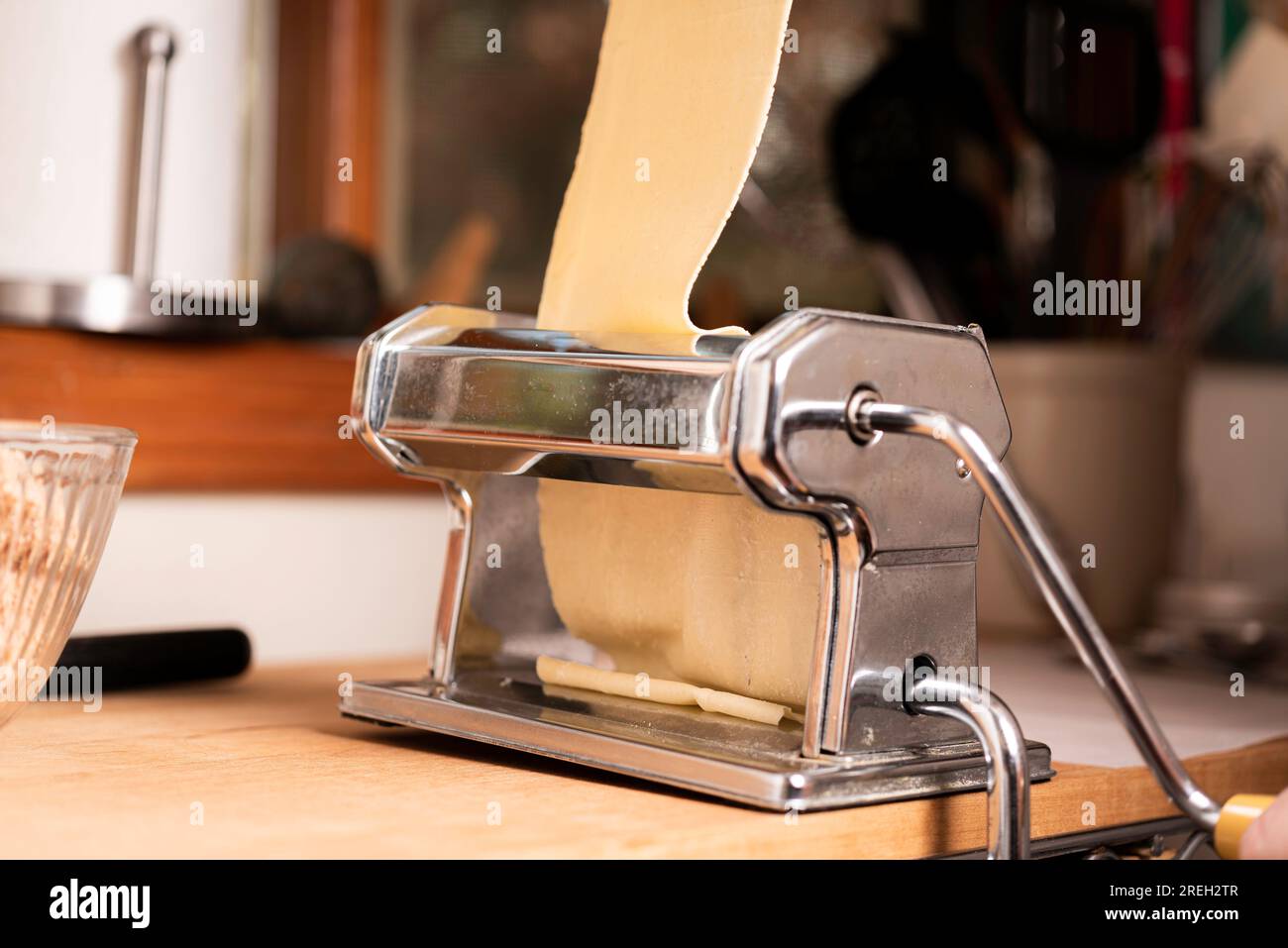 https://c8.alamy.com/comp/2REH2TR/making-pasta-and-tortellini-at-home-on-wooden-rack-and-chrome-pasta-maker-2REH2TR.jpg