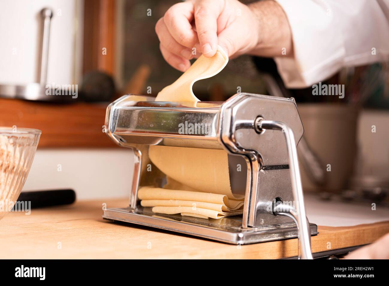 https://c8.alamy.com/comp/2REH2W1/making-pasta-and-tortellini-at-home-on-wooden-rack-and-chrome-pasta-maker-2REH2W1.jpg