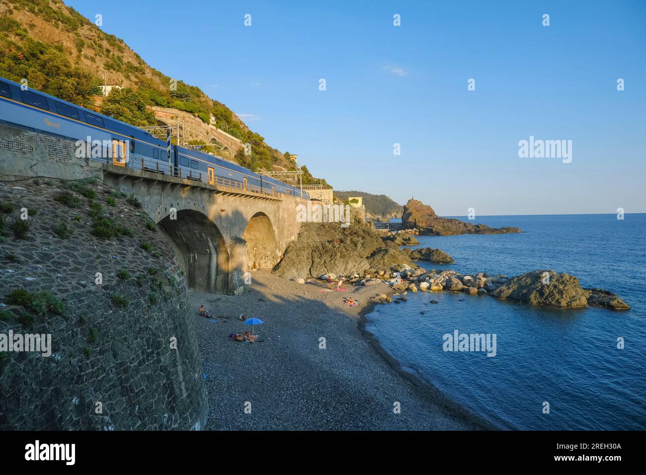 train coming to the station in Framura over the Ligurian sea, cliffs, and horizon of the national park Cinque Terre Stock Photo