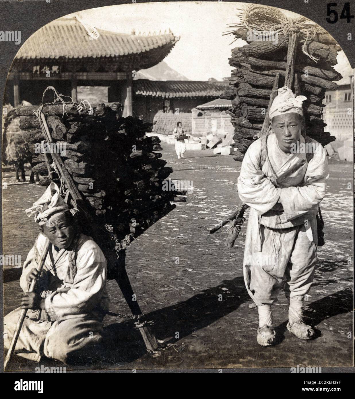 Deux portefaix charge de charbon de bois, dans une rue de Seoul, Coree. Photographie, 1904.  . Stock Photo